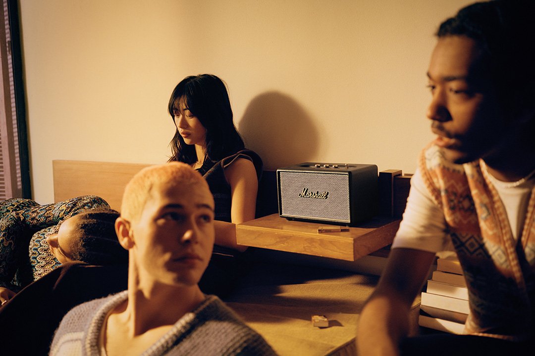 Friends sitting around listening to Marshall Acton III powered speaker in black