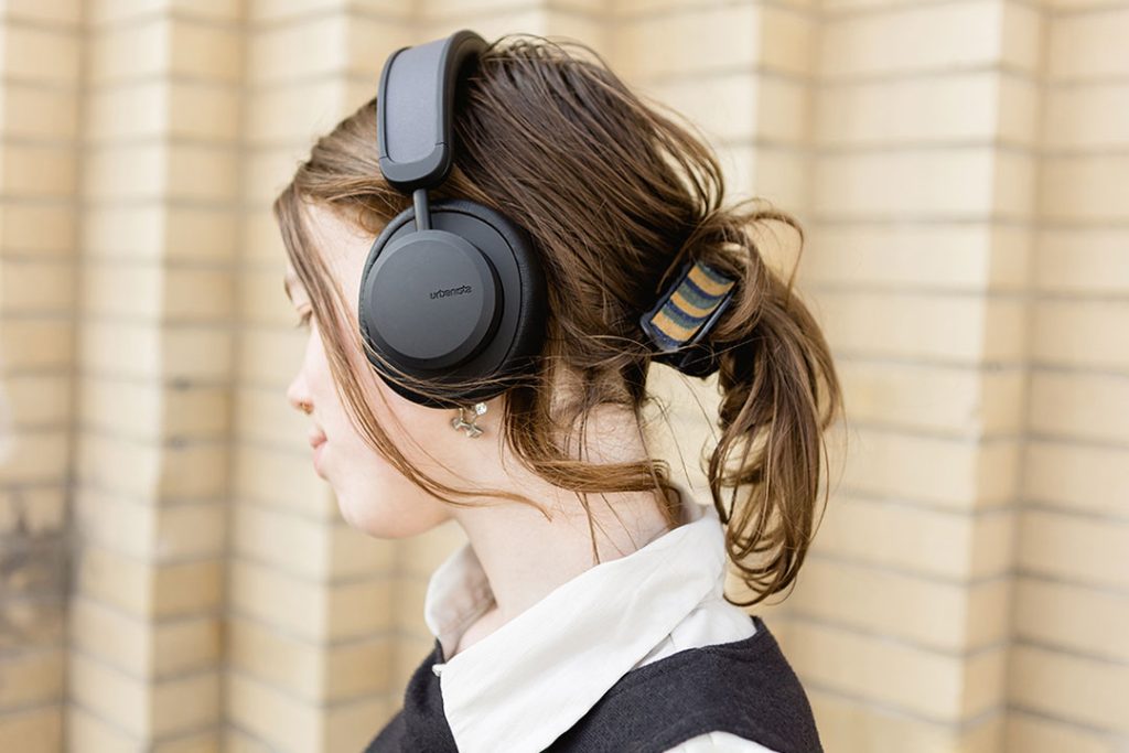 Young female wearing Urbanista Los Angeles solar power headphones in black