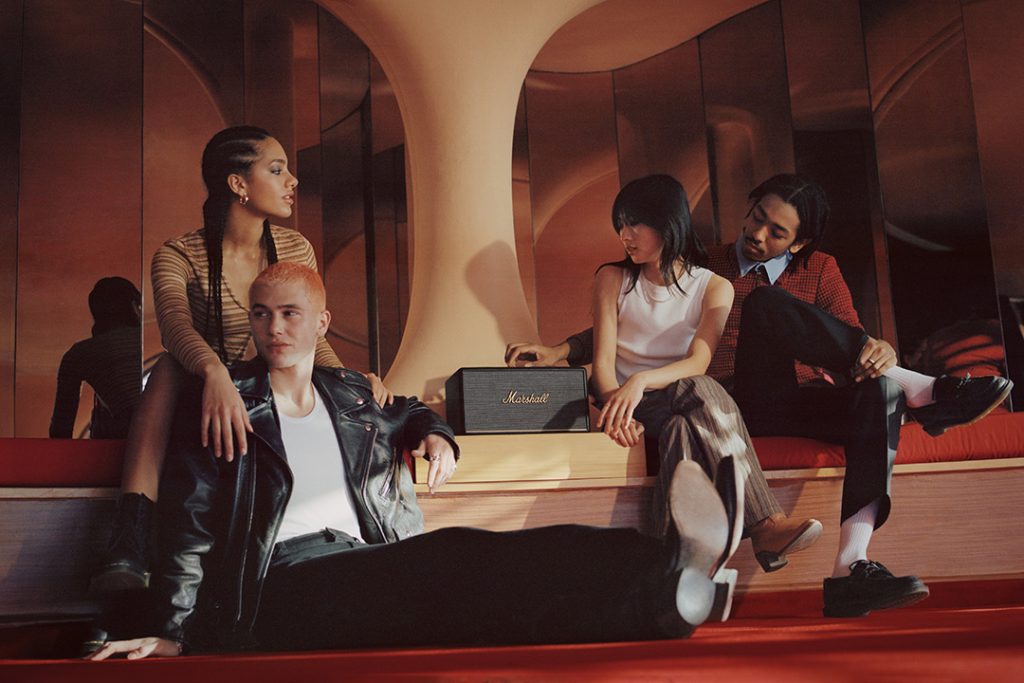 Friends listening to Marshall Stanmore III powered speaker in black in lobby