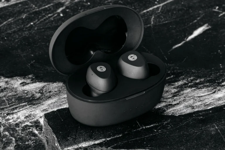 Grado GT220 Earphones sitting in charging case resting on black marble countertop