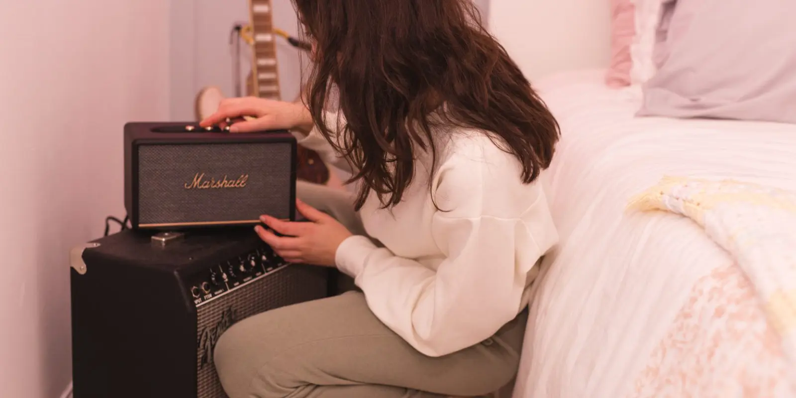 girl in bedroom adjusting marshall speaker
