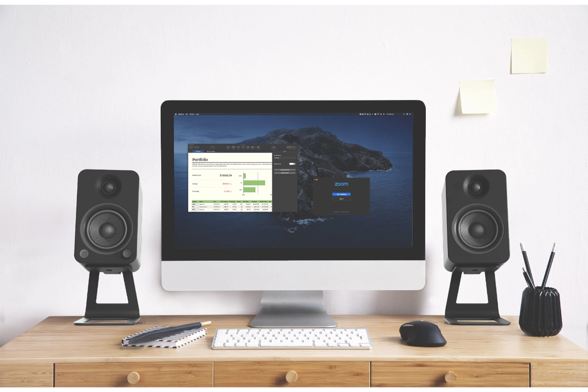 Kanto SE4 Speaker Stands holding black speakers beside apple computer on desktop. NEat desktop setup