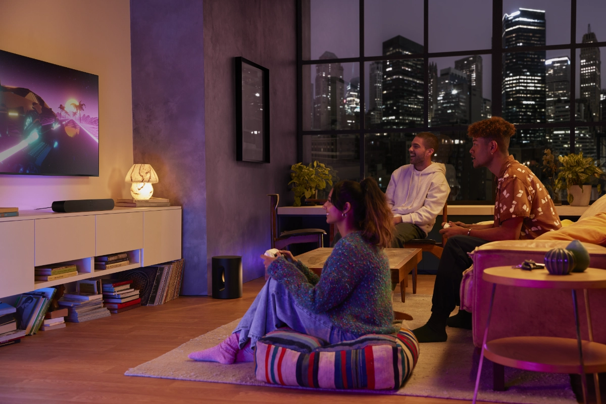 Sonos Entertainment Set with beam, set up in a living room, as friends gather around to play games together.