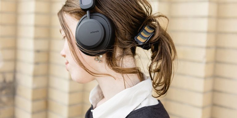 Young female wearing Urbanista Los Angeles solar power headphones in black