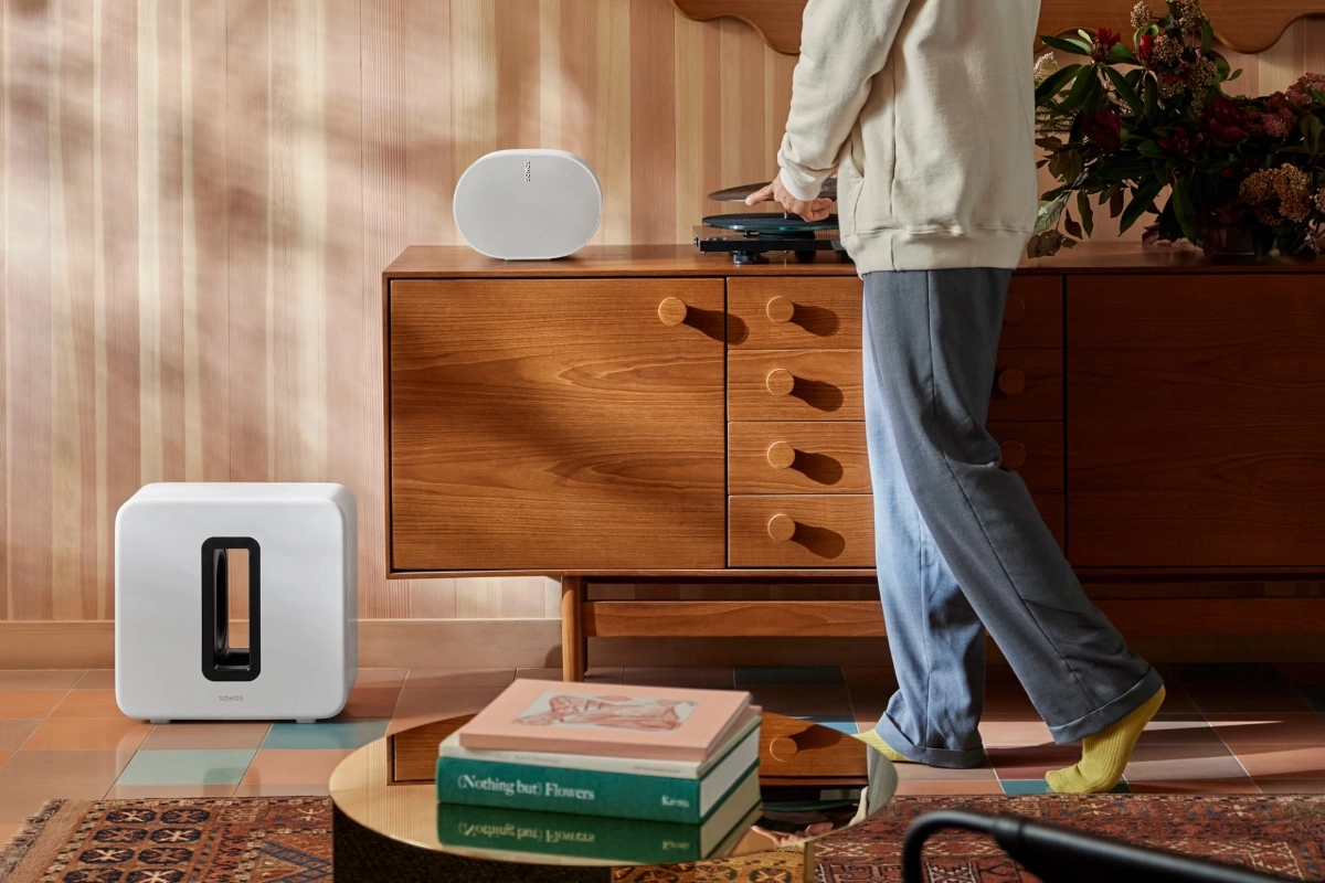 A sonos sub 4 rests beside a wooden credenza in a cozy living room, next to a sonos era 300