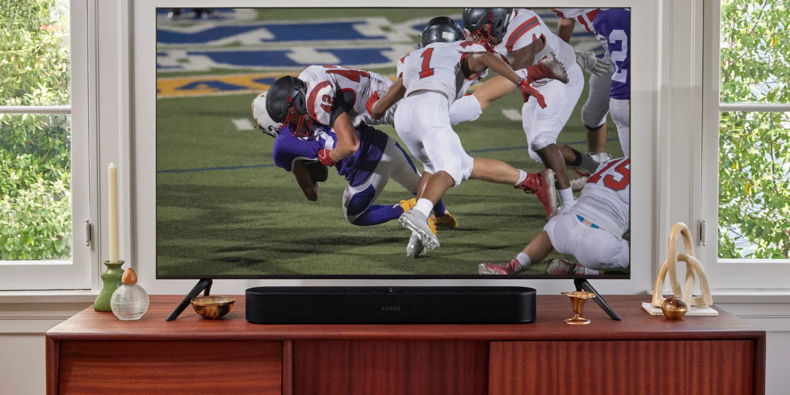Football playing on a TV on a living room shelf with elegant decorations.