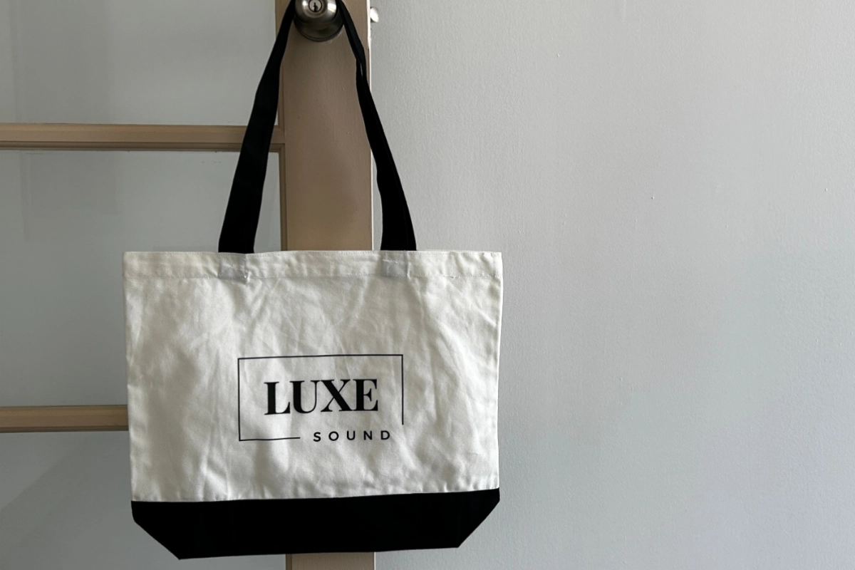 Luxe Sound Logo tote hanging on door handle